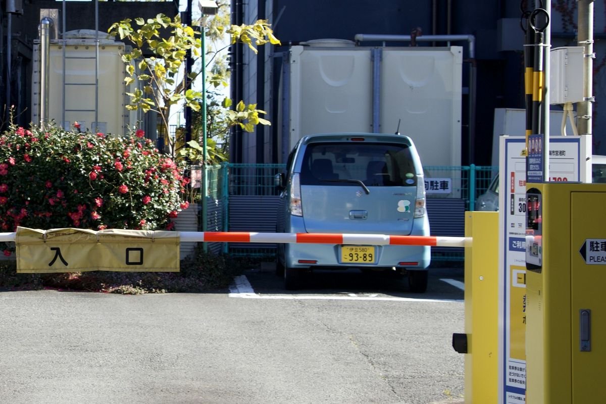 Vehículo detenido detrás de la barrera de ingreso a un estacionamiento, con lectura de patente