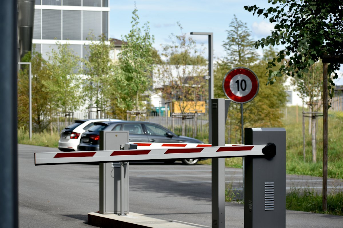 Acceso vehicular con barrera y autos esperando, con detección de vehículos